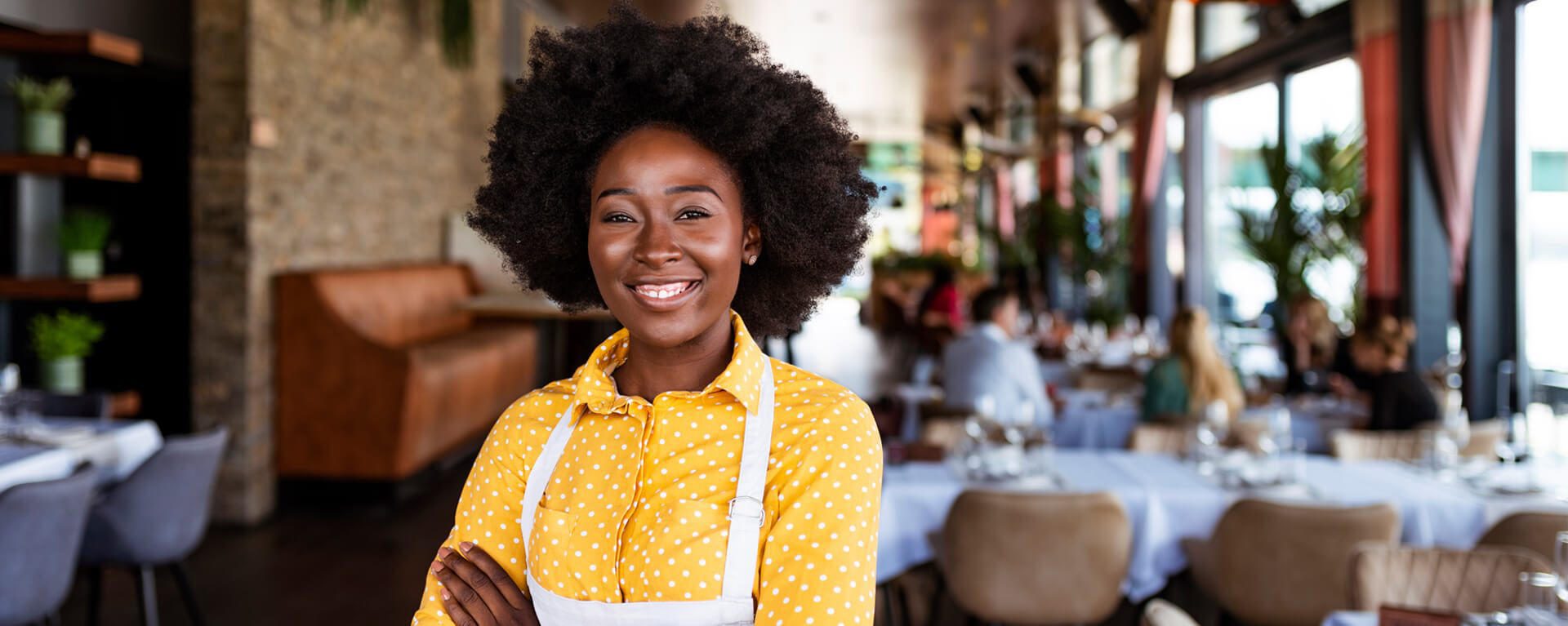 Woman smiling at camera while crossing arms.