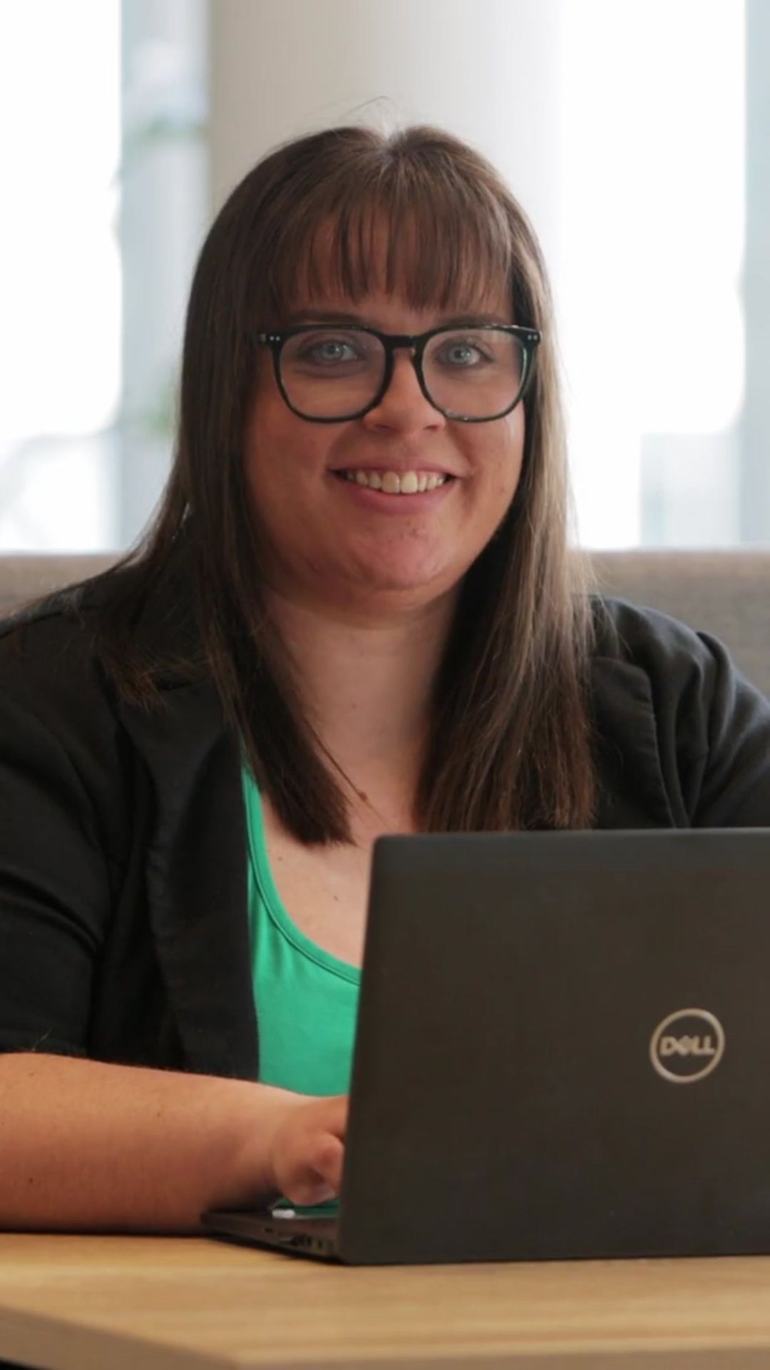 An image of Linda McArthur on her laptop and smiling at the camera.