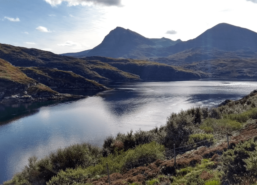 A body of water with mountains in the background