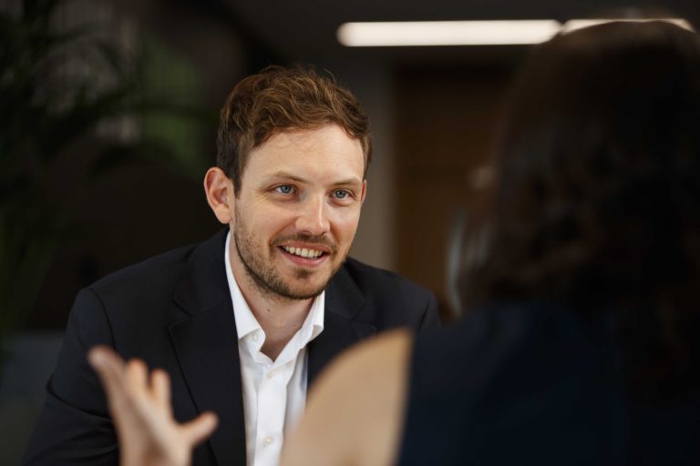 An image of an AAB employee smiling and talking to an employee opposite.