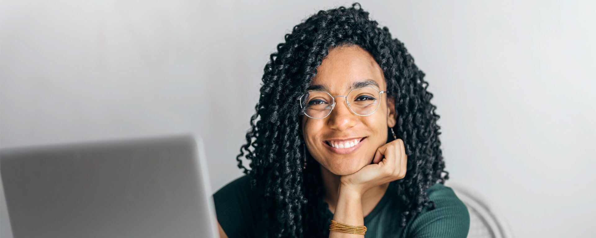 An image of a women with black curly hair smiling at the camera.