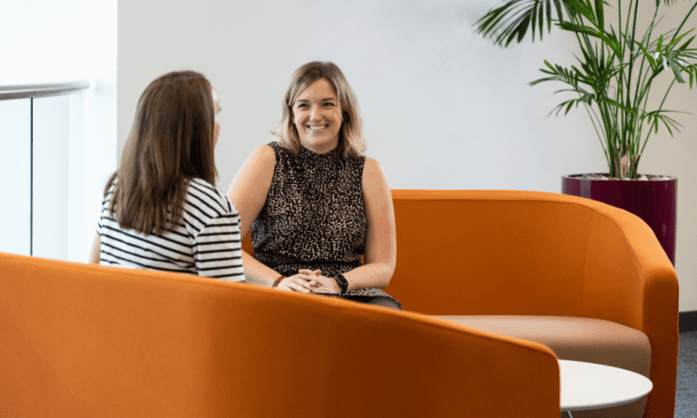 Two people laughing on a sofa at AAB.