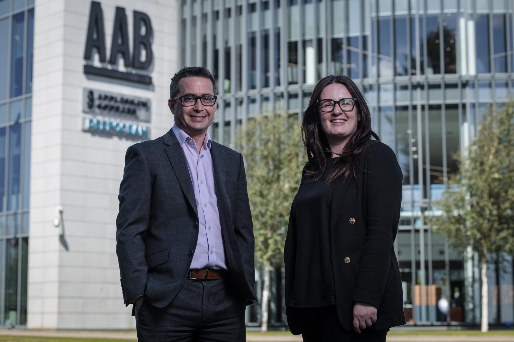 A press release image of Niall Pirie and Lauren McCluskey standing outside the Aberdeen office.