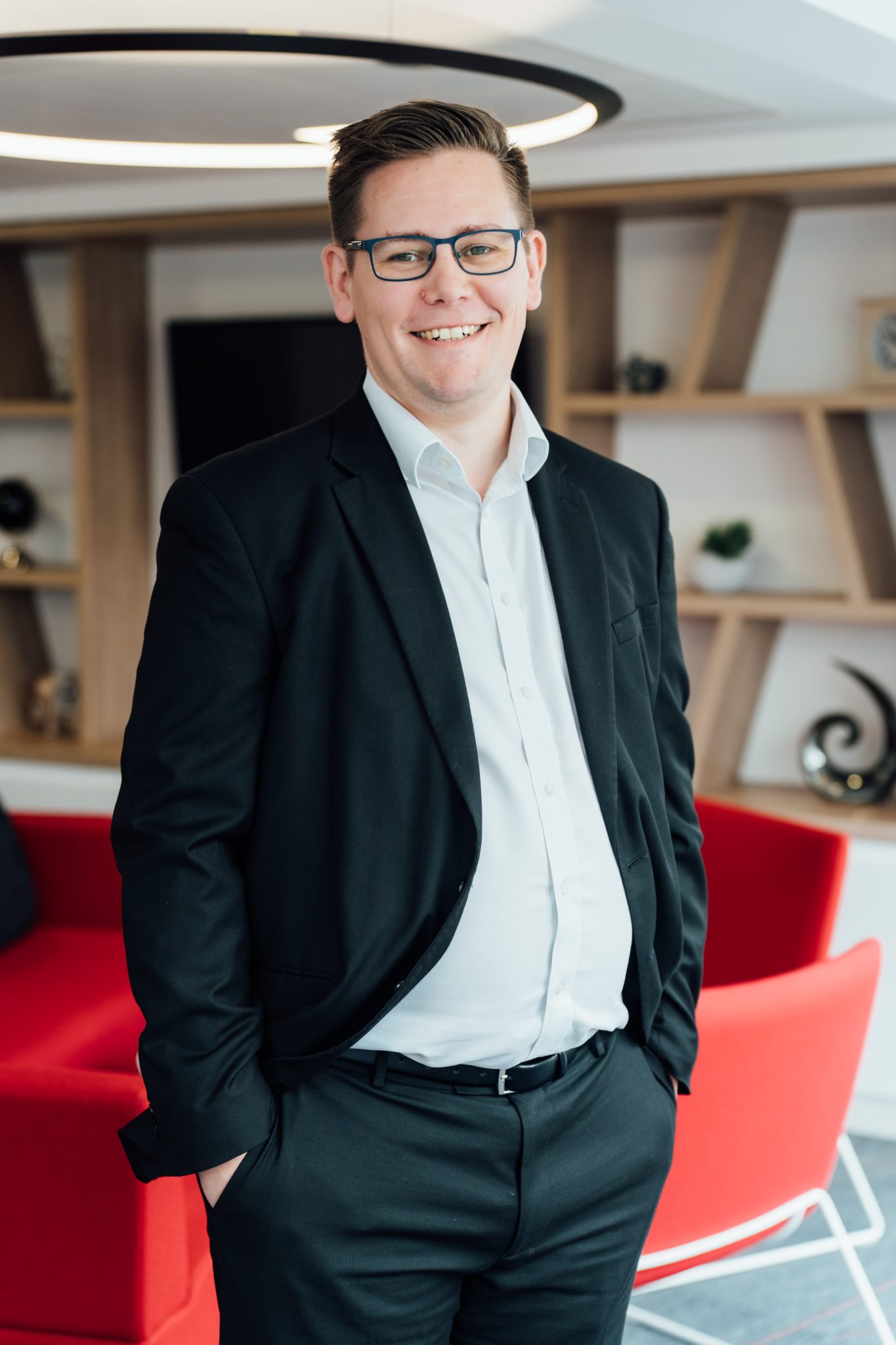An image of Andrew Philbin smiling at the camera with his hands in his pockets.