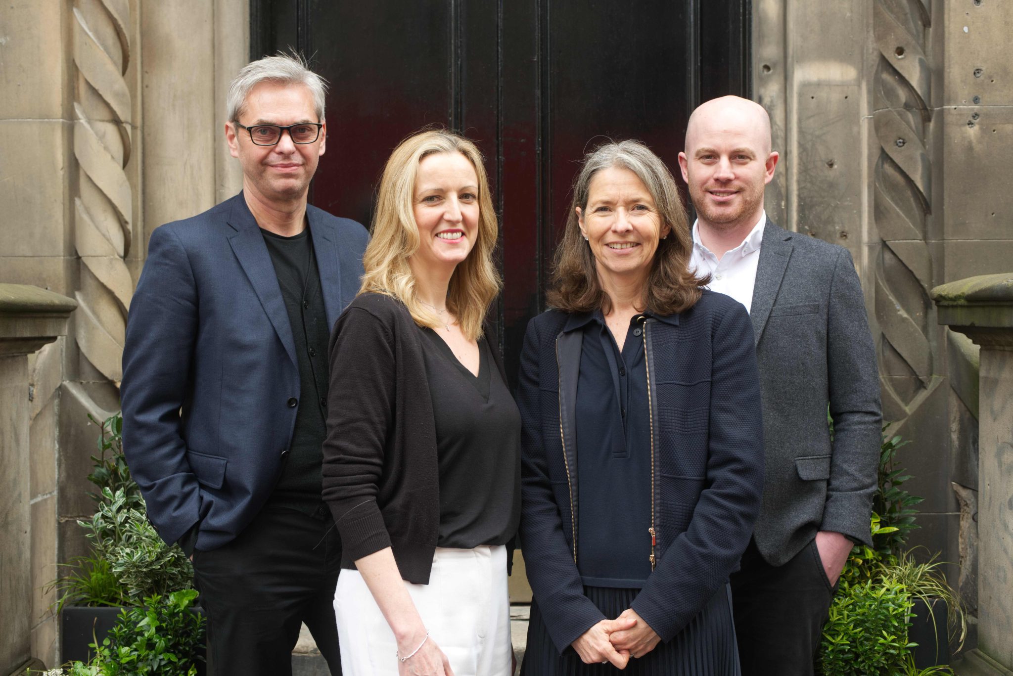 An image of Neil Robb, Lyn Calder, Emma Lancaster and John Beevers standing outside wearing smart clothing and smiling at the camera.