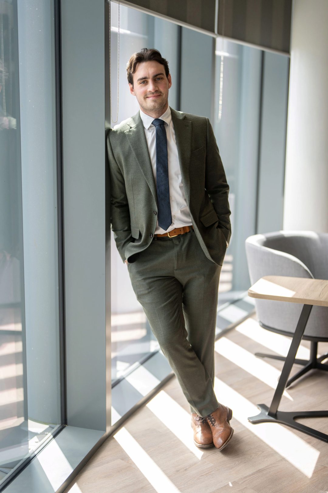 Lewis Forsyth standing against a pillar in the AAB office smiling at the camera