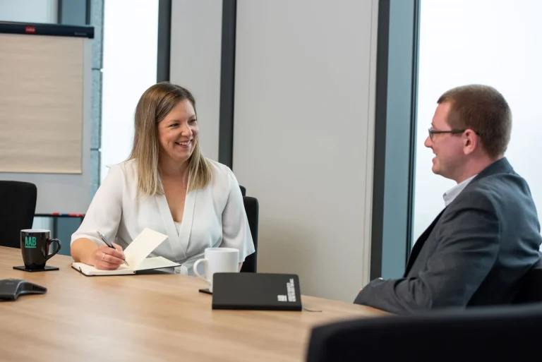 Male and female AAB staff in meeting together.