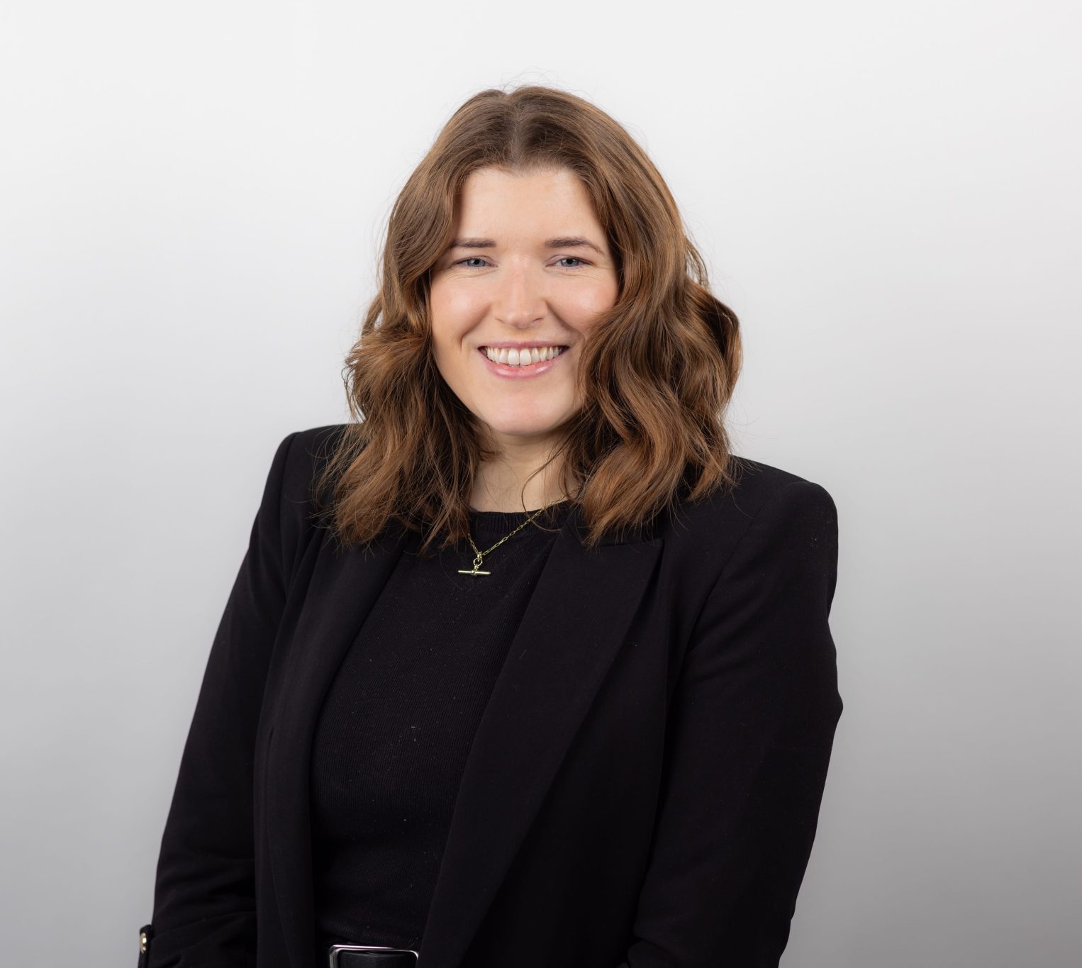 An image of Niamh Ryan wearing a black outfit and smiling at the camera.