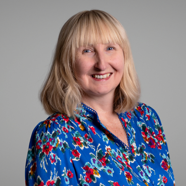 An image of Katherine Joyce wearing a blue top and smiling at the camera.