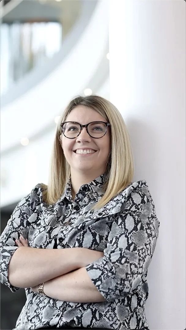 Laura Rowson, smiling at the camera with her arms folded