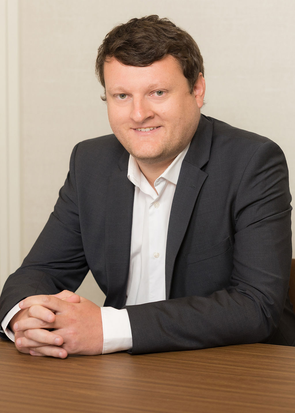 An image of Andy Mitchell wearing a black suit jacket and white shirt.