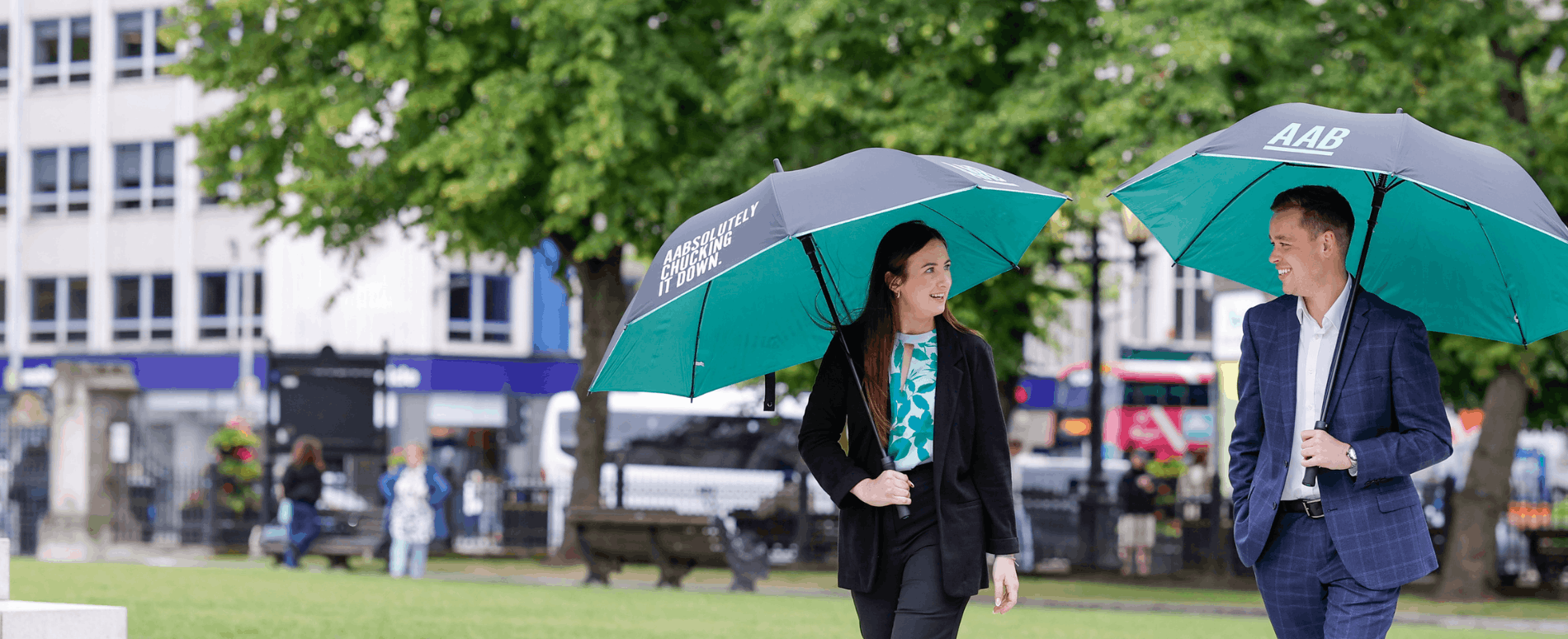 AAB employees walking with green umbrellas.